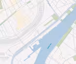 Karta som visar en del av ett hamnområde märkt som "Sydhavnen" med en å eller vattenväg som löper parallellt med ett vägnät. Kartan visar olika geometriska former som representerar byggnader och tomter, genomskärda av vägar och grönområden.